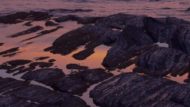 Twilight reflected in the sea between rocks