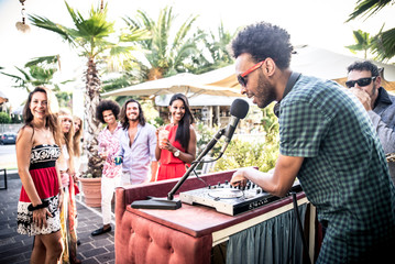 Friends dancing in a lounge bar, with dj set