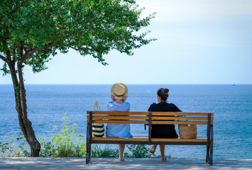 girls on a bench against the sea