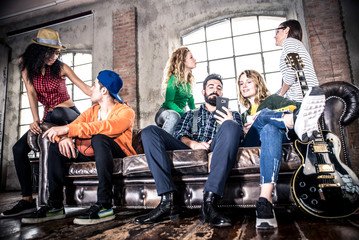 Fototapeta na wymiar Mixed race group having fun on the couch in a loft
