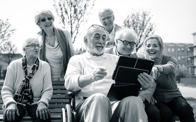 Fototapeta na wymiar Group of senior looking funny videos on a digital device