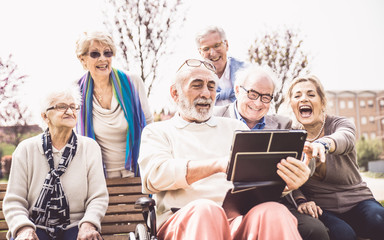 Group of senior looking funny videos on a digital device
