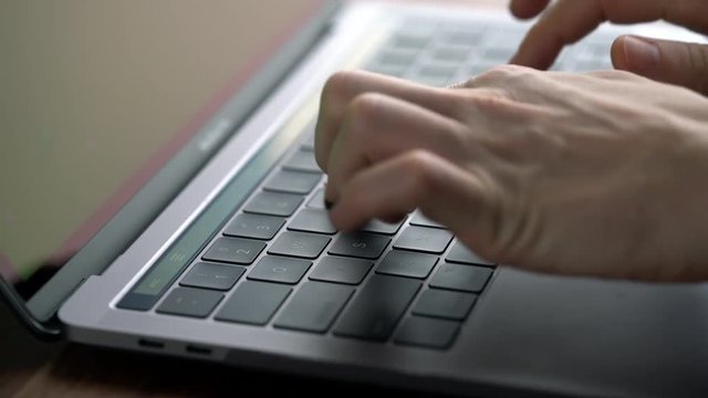 Close up hands typing on laptop computer keyboard with green screen