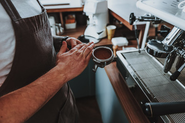 Close up of hand tapping filter holder with coffee