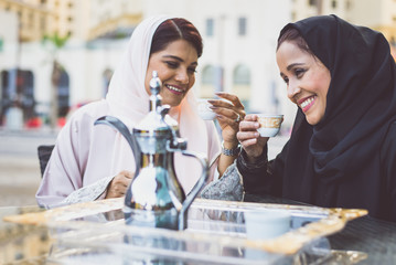 Two arabian girls spending time togehter outdoor making activities