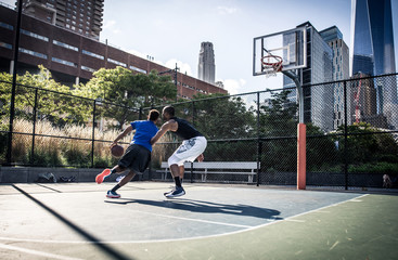 Two street basketball players playing hard on the court