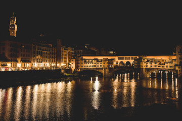 Fototapeta na wymiar Ponte Vecchio and the buildings close by at night reflecting on the river Arno. Florence, Italy.