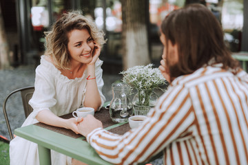 Beautiful couple sitting at the table and holding hands