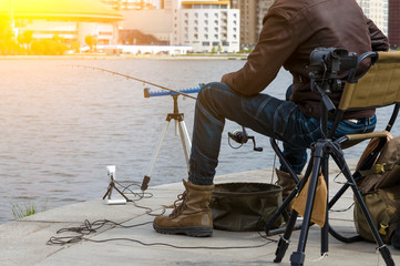 close-up details, two video cameras shoot a man blogger on the street. Quay, fishing, fishing rod,...