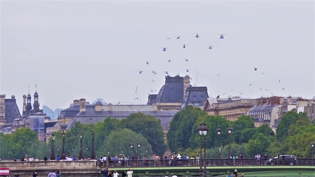 Paris, France - July 14 2019: Bastille Day Aircrafts Parade. Helicopter Squadrons and birds are flying over the seine river.