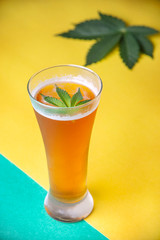 Detail of cold glass of beer with cannabis leaf