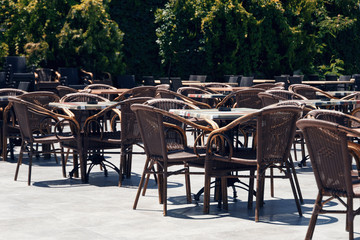 Empty tables in an open-air cafe at noon. Hot summer day