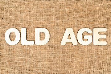 word old age of wooden letters on sackcloth
