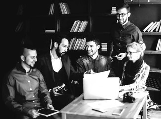 friendly team of copywriters in the workplace in modern office black and white photo