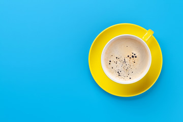 Yellow coffee cup over blue background