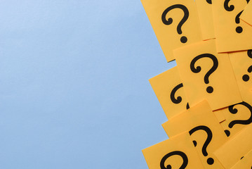 Printed question marks on yellow paper or card