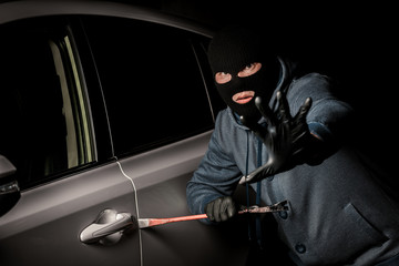 male thief is going to open the car door with a crowbar.