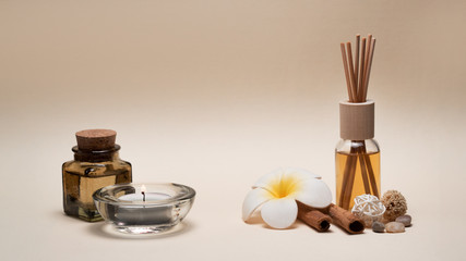 Fototapeta na wymiar Beautiful spa composition with candles, frangipani flower, oil flasks and other decor elements.