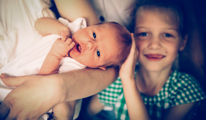 portrait of big sister with newborn baby