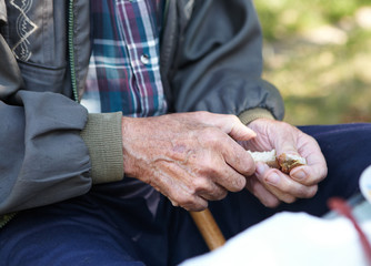 Elderly poor man eating bread