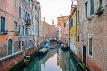 Canal with boats between the colorful houses.