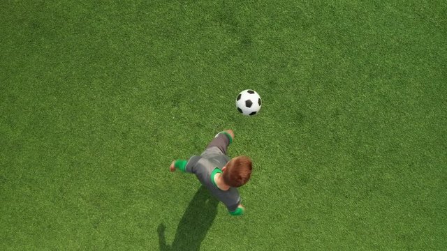 Top view from drone on football field football player stuffs ball. Soccer trains before match on football field on sunny day.