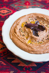 Homemade red kidney bean hummus with basil leaves. Mashed beans Arabian puree. Vegan food.