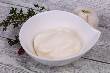 Mayonnaise sauce in the white bowl served thyme and garlic