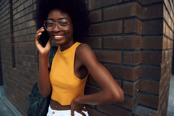 Smiling young afro-american lady walking in the city