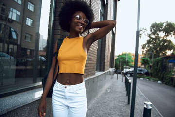 Smiling pretty lady in glasses walking in the city