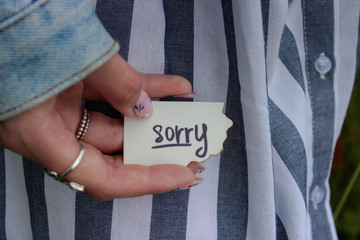 hand of a girl with a note of apology