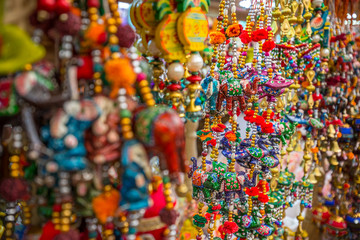 Colourful traditional handmade Indian decorative beads and crafted animal decorations and souvenirs hang outside a market stall in the Little India area of Singapore, Asia