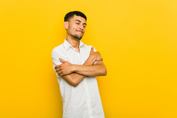 Young hispanic man hugs, smiling carefree and happy.