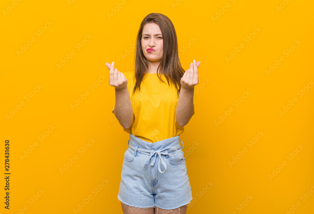 Wall mural Young woman teenager wearing a yellow shirt showing that she has no money.