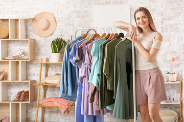 Young woman standing near clothes rack in dressing room