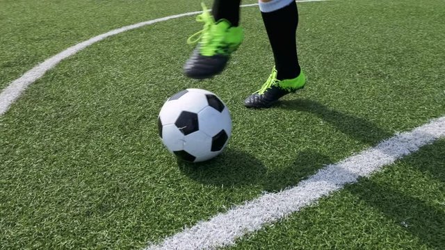 Demonstration football tricks. Footballer touches the ball alternately with their feet Slow motion. Football team player trains on the football field before a match in large stadium. Soccer. Sport
