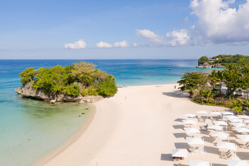 Blue sea and white sandy beach in sunny weather. Beautiful sea coast on the island of Barokai, Philippines, top view.