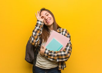 Young student woman confident doing ok gesture on eye