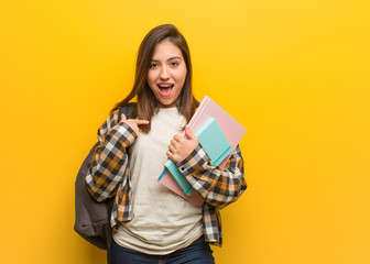 Young student woman surprised, feels successful and prosperous