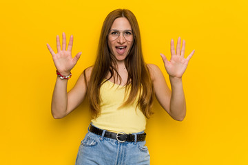 Obraz premium Young redhead ginger woman with freckless showing number ten with hands.