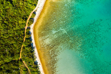 Adriatic sea in Croatia, Dugi otok island shore, pine woods and hidden secret beach from drone