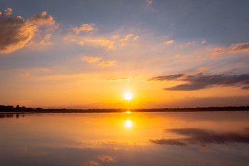 Fototapeta na wymiar Sunset reflection lagoon. beautiful sunset behind the clouds and blue sky above the over lagoon landscape background. dramatic sky with cloud at sunset