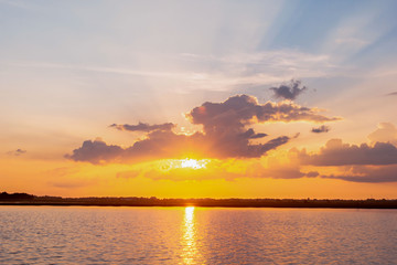 Sunset reflection lagoon. beautiful sunset behind the clouds and blue sky above the over lagoon landscape background. dramatic sky with cloud at sunset