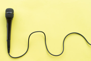 microphone for blogger, journalist or musician work on yellow background. karaoke microphone. top view mock up top view space for text