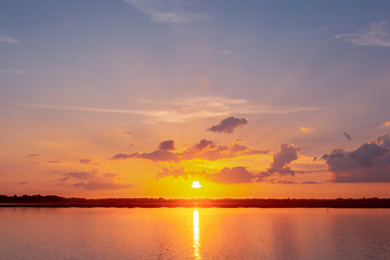 Sunset reflection lagoon. beautiful sunset behind the clouds and blue sky above the over lagoon landscape background. dramatic sky with cloud at sunset