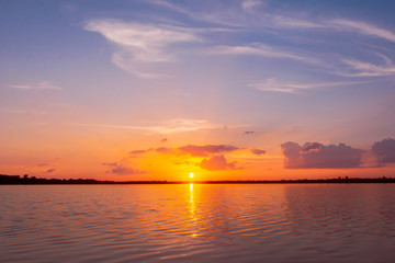 Sunset reflection lagoon. beautiful sunset behind the clouds and blue sky above the over lagoon landscape background. dramatic sky with cloud at sunset