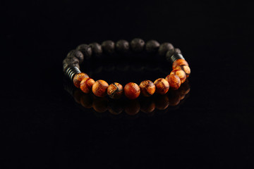 Shamballa bracelet made of wood on a black mirrored background