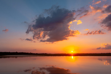Sunset reflection lagoon. beautiful sunset behind the clouds and blue sky above the over lagoon landscape background. dramatic sky with cloud at sunset