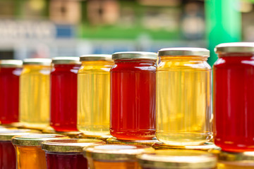 Pile of glass honey jars on the marketplace counter in Belgrade. Close up.