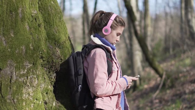 Traveler girl in the forest with mobile phone